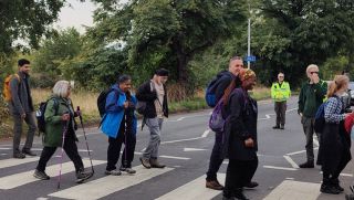epping forest big walk participants crossing road with the support from City of London Corporation Forest Keepers
